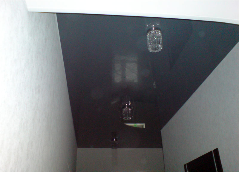 Глянцевый натяжной потолок из темного полотна с накладными светильниками