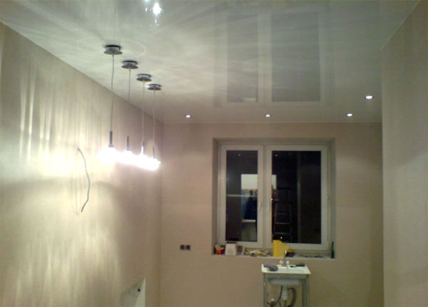 Глянцевый натяжной потолок с элементами подсветки кухни и встроенными светильниками